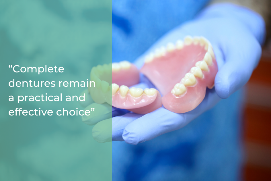Gloved hands holding a set of complete dentures, with a text overlay stating, "Complete dentures remain a practical and effective tooth replacement choice.